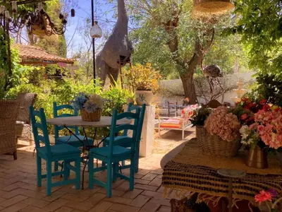 a wooden table with chairs and plants on it at Casa De Mondo in Boliqueime