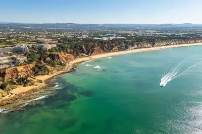 an aerial view of a boat in the water on a beach at T2 Eucalipto 2A by Algarneto in Olhos de Água