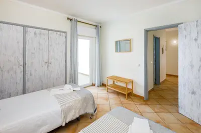 a bedroom with two beds and a table at Villa Nobre by The Portuguese Butler in Albufeira