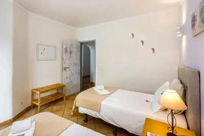 a small room with two beds and a table at Villa Nobre by The Portuguese Butler in Albufeira