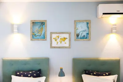 two green chairs in a room with paintings on the wall at Villa Nobre by The Portuguese Butler in Albufeira