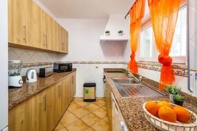 a kitchen with a sink and a bowl of oranges at Villa Nobre by The Portuguese Butler in Albufeira