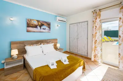 a bedroom with a bed and a balcony at Villa Nobre by The Portuguese Butler in Albufeira