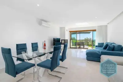 a living room with a glass table and blue chairs at Patroves Sea View - Dream Lodging in Albufeira