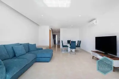 a living room with a blue couch and a flat screen tv at Patroves Sea View - Dream Lodging in Albufeira