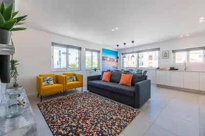 a living room with a couch and two chairs and a rug at Central Town 2-Bedroom Apartment Albufeira in Albufeira