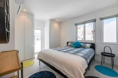 a bedroom with a bed and two windows at Central Town 2-Bedroom Apartment Albufeira in Albufeira