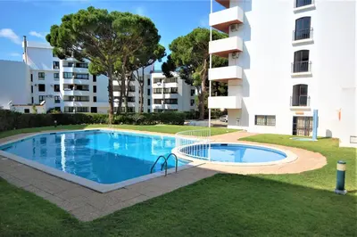 a swimming pool in front of a building at T0 Estudio Leziria - Swimming pool in Vilamoura