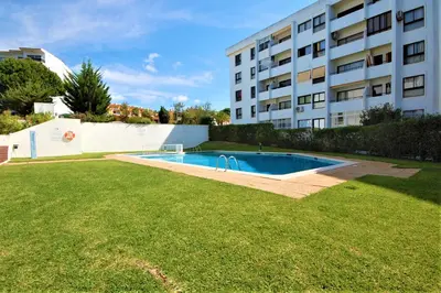 a swimming pool in a yard next to a building at T0 Estudio Leziria - Swimming pool in Vilamoura