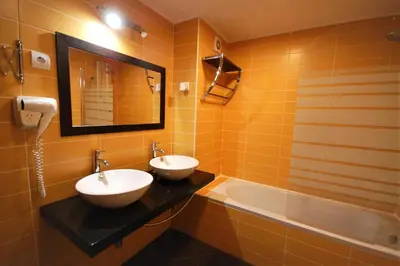 a bathroom with two sinks and a tub and a mirror at T0 Estudio Leziria - Swimming pool in Vilamoura