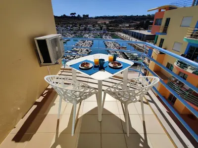 a balcony with a table with food and drinks on it at Albufeira Marina Views in Albufeira