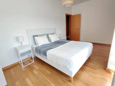 a bedroom with a large white bed and a night stand at Albufeira Marina Views in Albufeira