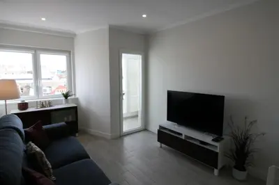a living room with a couch and a flat screen tv at Downtown Dreams in Faro