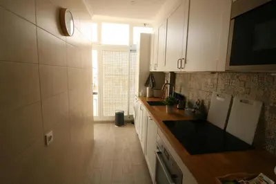 a kitchen with white cabinets and a large window at Downtown Dreams in Faro