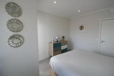 a bedroom with a bed and two mirrors on the wall at Downtown Dreams in Faro