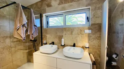 a bathroom with two white sinks and a shower at Moderna by Check-in Portugal in Quarteira