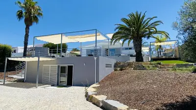 a modern house with a balcony and palm trees at Moderna by Check-in Portugal in Quarteira