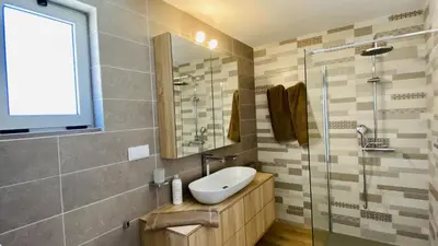 a bathroom with a sink and a glass shower at Moderna by Check-in Portugal in Quarteira