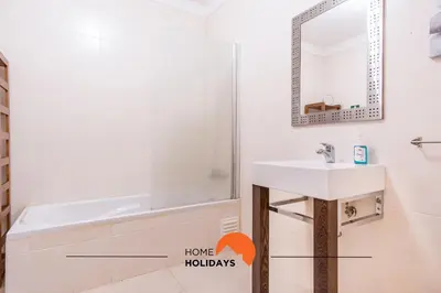a bathroom with a sink and a tub and a mirror at #055 São José V by Home Holidays in Albufeira