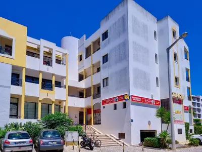 a white building with cars parked in front of it at FLH Vilamoura Summer Flat with Pool in Vilamoura