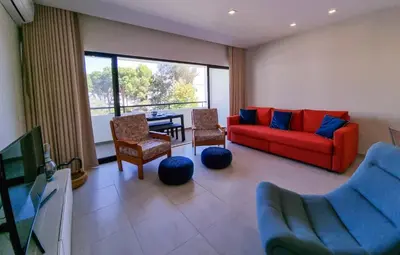 a living room with a red couch and chairs at FLH Vilamoura Summer Flat with Pool in Vilamoura