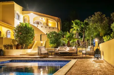 a villa with a swimming pool at night at Casa Lusitania 19 in Faro