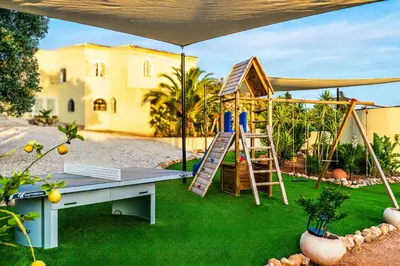a playground with a table and a ladder and a house at Casa Lusitania 19 in Faro