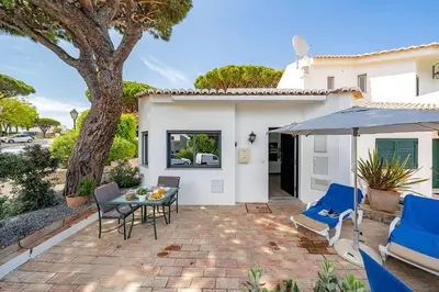 a patio with chairs and a table and an umbrella at Casa Alessa - Vale de Lobo in Almancil
