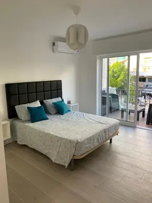 a bedroom with a large bed with blue pillows at Beira mar in Albufeira