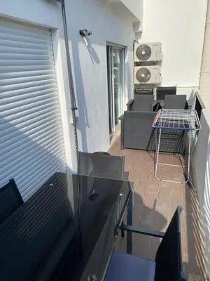 a balcony with a couch and a table in a room at Beira mar in Albufeira