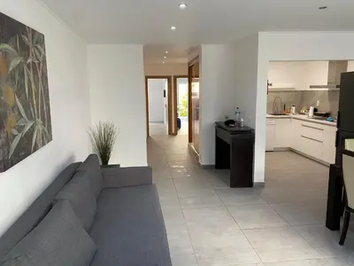 a living room with a couch and a kitchen at Beira mar in Albufeira