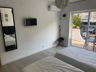 a bedroom with a bed and a mirror and a window at Beira mar in Albufeira