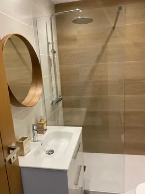 a bathroom with a sink and a shower with a mirror at Beira mar in Albufeira