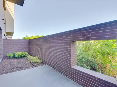 a brick wall with a large window on it at L'orangerie modern 1bdr apartment, ground floor in Vilamoura