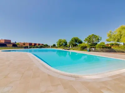 a large swimming pool with blue water at L'orangerie modern 1bdr apartment, ground floor in Vilamoura