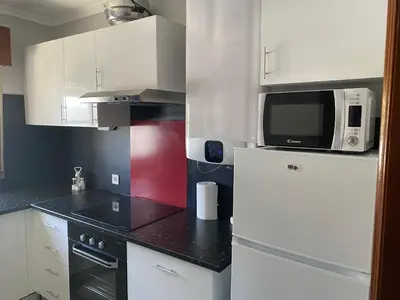 a kitchen with a white refrigerator and a microwave at Appartement T1 Albufeira Strip Oura in Albufeira