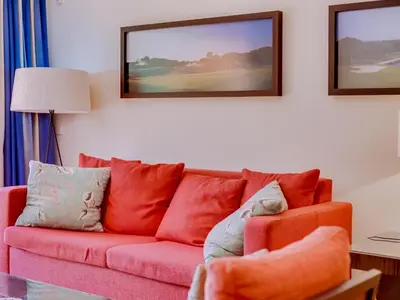 a living room with a pink couch with pillows at AL - Apartamento Vila Sol F5 L in Vilamoura