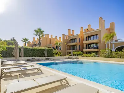 a villa with a swimming pool in front of a building at AL - Apartamento Vila Sol F5 L in Vilamoura