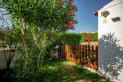 a fence with a tree in front of a house at LOTUS VILLA 2, ALBUFEIRA in Albufeira
