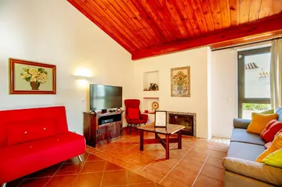 a living room with a red couch and a tv at LOTUS VILLA 2, ALBUFEIRA in Albufeira