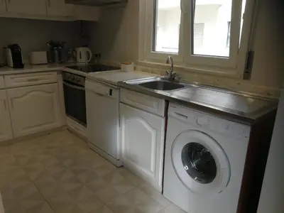 a kitchen with a washing machine and a sink at Casa do Algarve in Albufeira