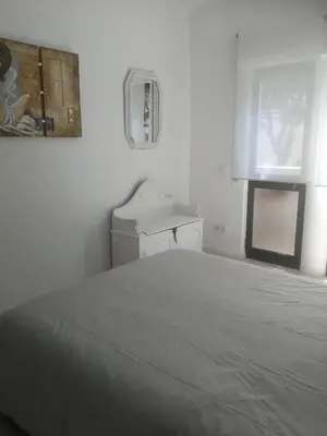 a white bedroom with a bed and a window at Casa do Algarve in Albufeira