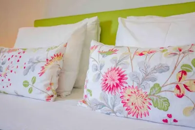 a bed with white pillows and flowers on it at Admirable 1 bedroom Marina view apt. Albufeira in Albufeira