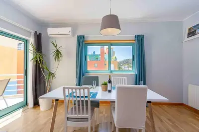 a dining room with a table and chairs and a window at Admirable 1 bedroom Marina view apt. Albufeira in Albufeira