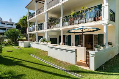 a large building with an umbrella on a lawn at Vale de Lobo by Intiholidays in Vale do Lobo