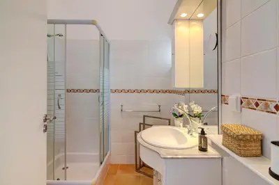 a white bathroom with a sink and a shower at Casa Estrela do Mar in Vale do Lobo