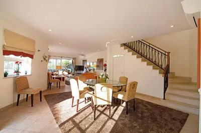 a dining room with a table and chairs and a staircase at Casa Valerie in Vale do Lobo
