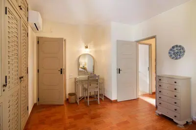 a hallway with white doors and a dresser and a mirror at Casa Allan in Vale do Lobo