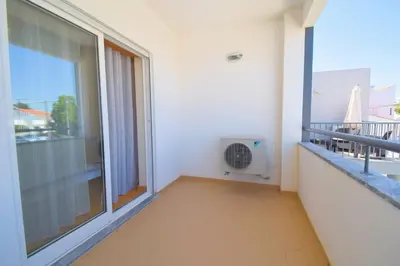 a balcony with a fan in a room with a window at Perfect New Apartment in Albufeira in Albufeira