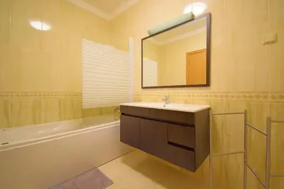 a bathroom with a sink and a mirror and a tub at Perfect New Apartment in Albufeira in Albufeira